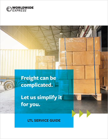 Stacks of large brown boxes on pallets are inside a warehouse near an open loading dock. Sunlight shines in. Text on a blue overlay reads, Freight can be complicated. Let us simplify it for you. The logo says, Worldwide Express.