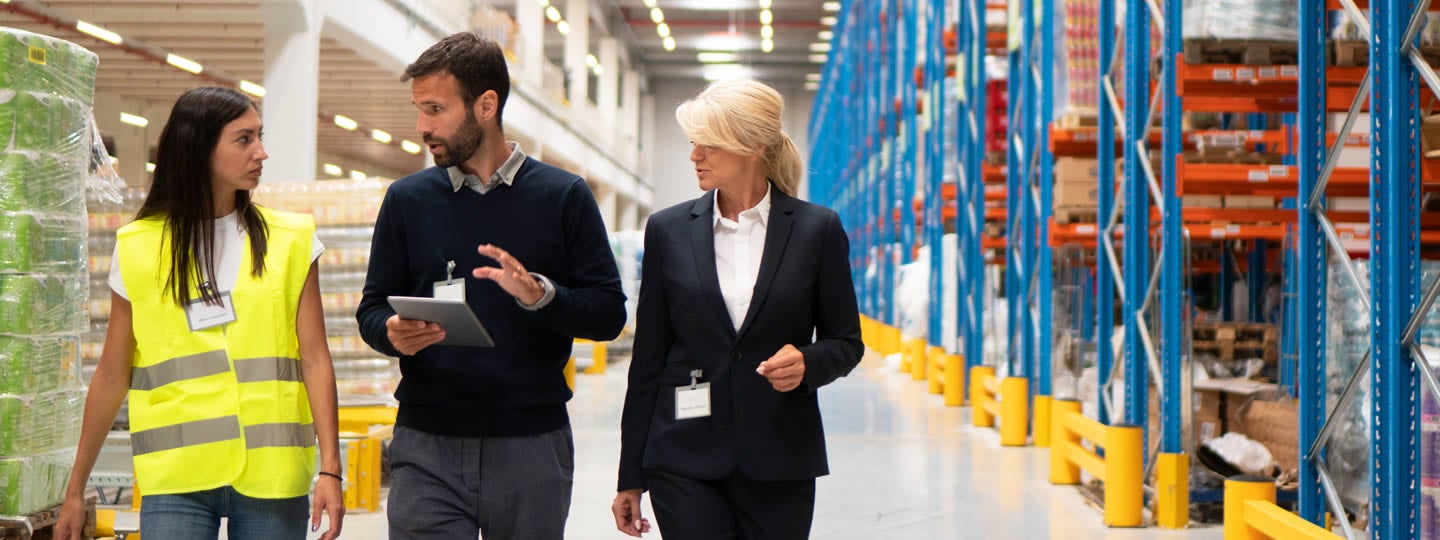 discussing with two women. One woman wears a suit