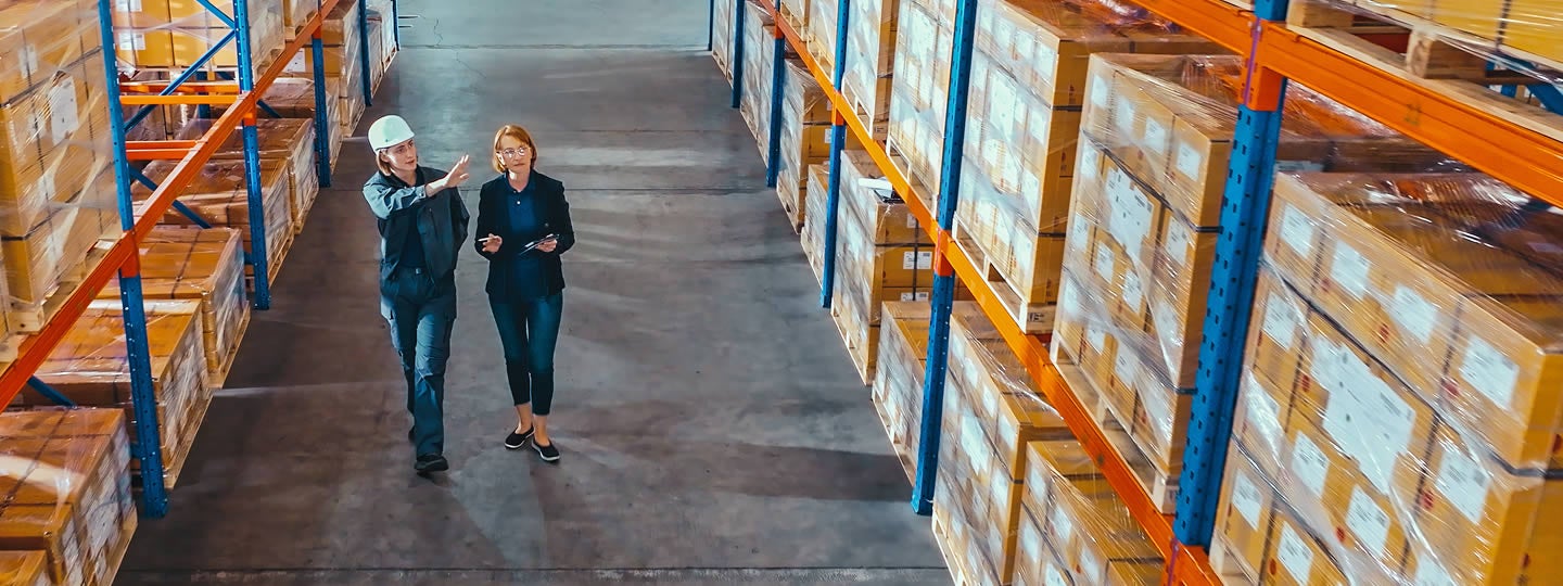 with arrows suggesting movement and route planning in shipping logistics.|Illustration of a person standing next to a monitor displaying a map of the USA with location pins. Nearby