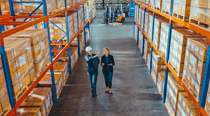 Illustration of a man at a monitor with a U.S. map and location pin. Connected boxes and a delivery truck highlight the small-business-shipping-hub theme