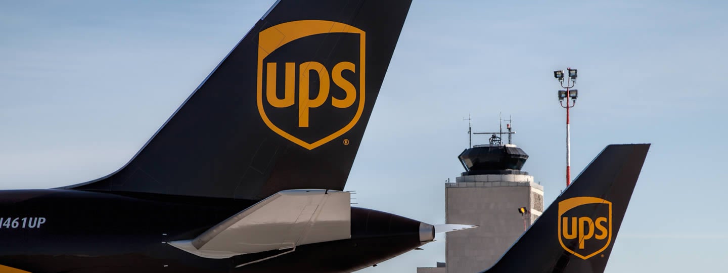 with stacked cardboard boxes inside.|Warehouse workers in motion