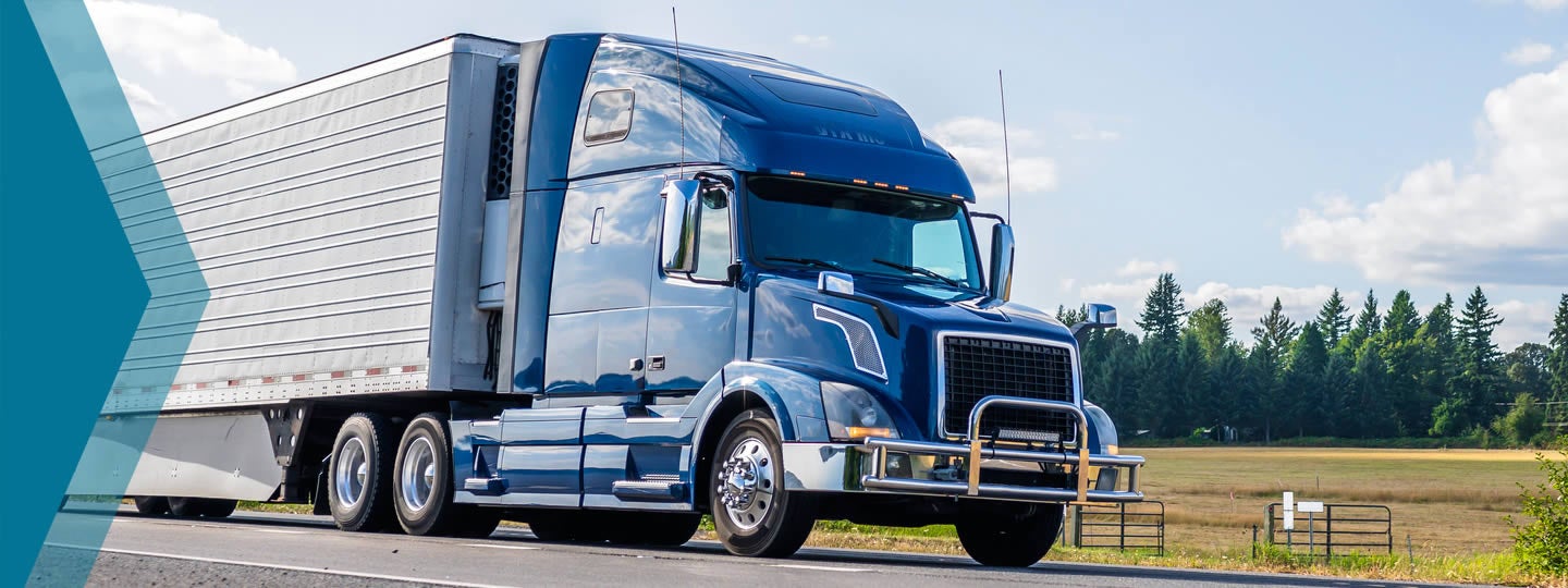 theres a green clock icon with an arrow indicating rotation. Fields and trees are visible in the background.|A blue semi-truck cruises down the road under a clear sky dotted with clouds. In the foreground