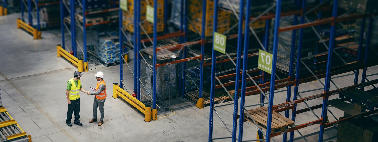 surrounded by tall racks stacked with pallets. The floor is clear
