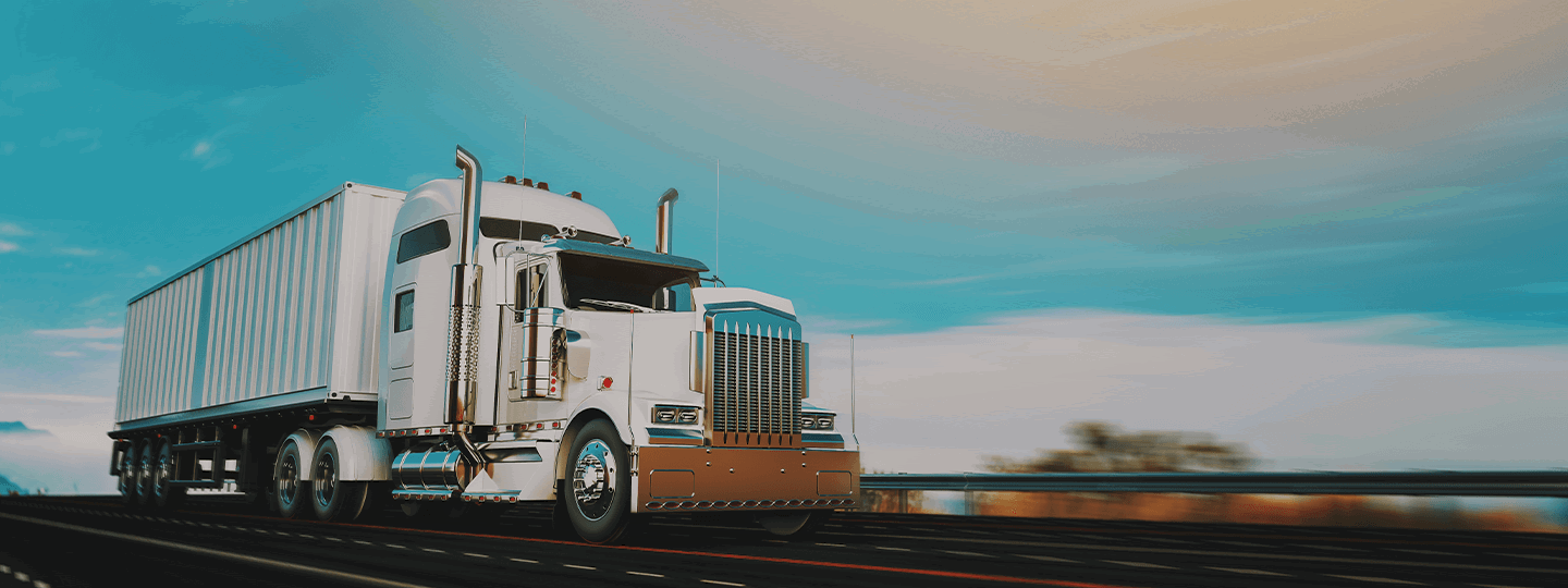 suggesting forward motion.|A white semi-truck with a large trailer