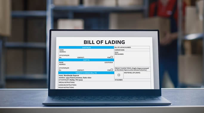 A laptop screen displays a digital bill of lading form in a warehouse