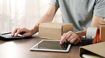 A person is working at a desk in their small-business shipping hub