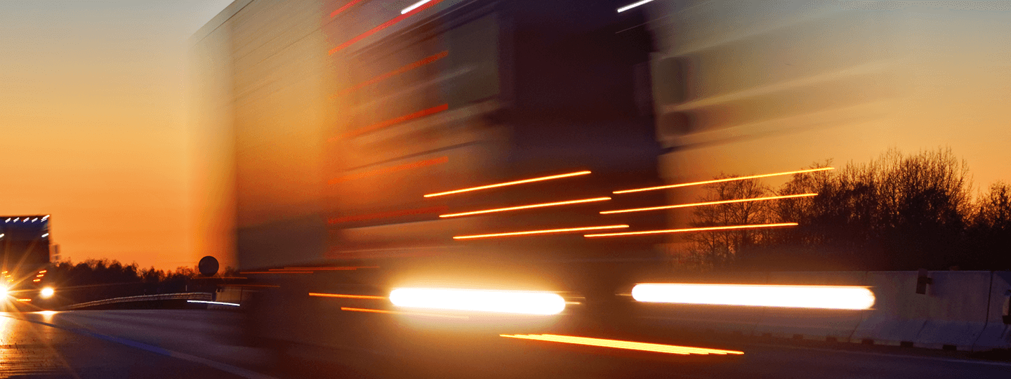 while the Worldwide Express logo graces the bottom.|Blurred image of a fast-moving truck on the highway at sunset