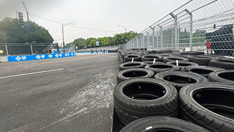 The street race track features a row of stacked tires on the right