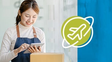 A person in a white turtleneck and apron smiles while using a tablet. Next to them is an icon of an airplane surrounded by a circular outline