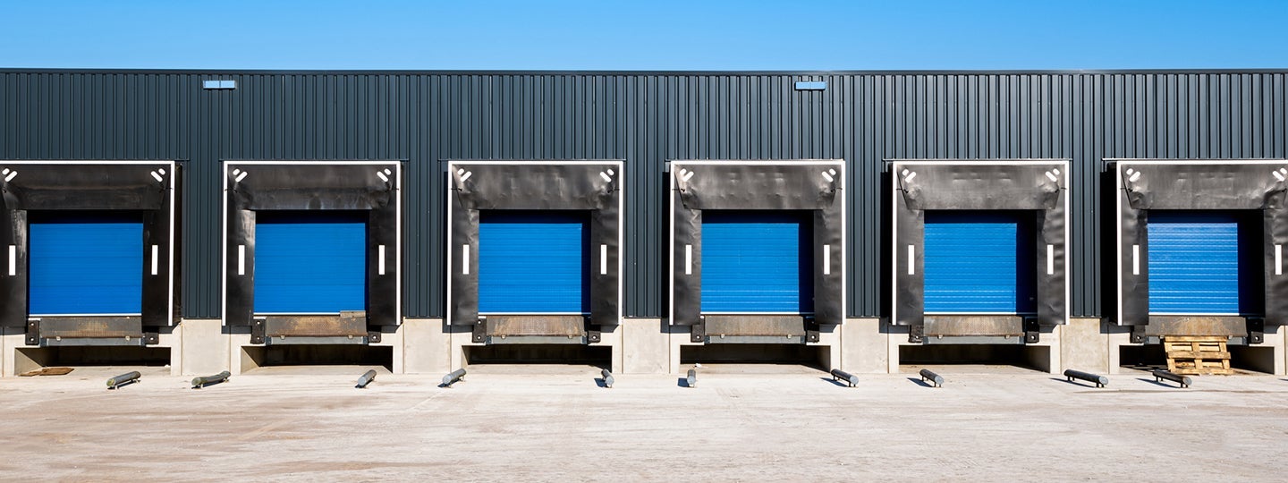 possibly incurring accessorial charges. Each door is equipped with protective black bumpers. The ground is paved