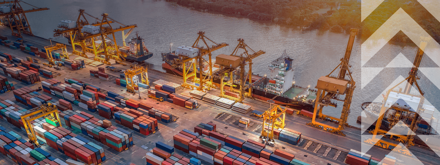 featuring large cranes and numerous colorful shipping containers arranged in rows. A cargo ship is docked at the port