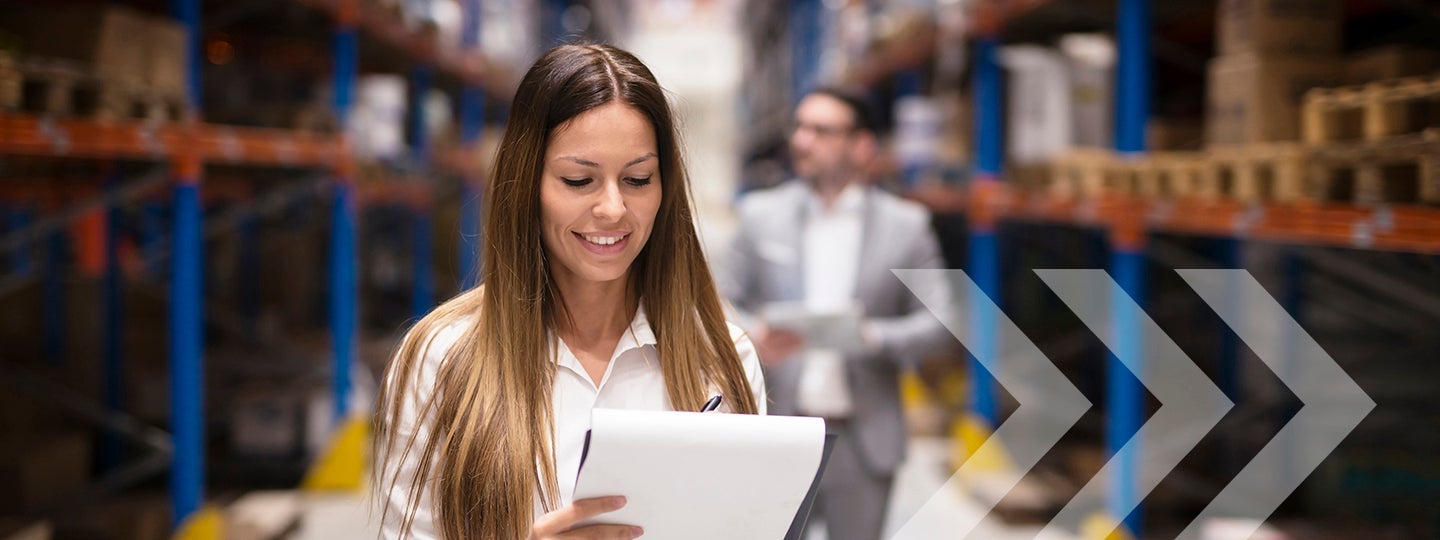 a person in a suit stands among shelves filled with boxes. Overlaying arrows point to the right.|A woman with long brown hair is smiling while reviewing a clipboard in a bustling warehouse