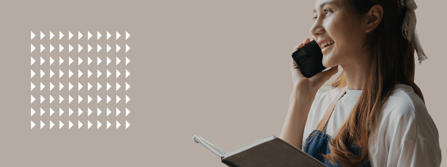 clutching a notebook in one hand and chatting on a smartphone. Nearby