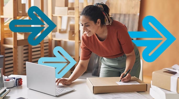 A woman in an orange shirt leans over a table