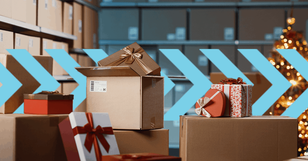 A stack of gift-wrapped boxes in a warehouse setting with large blue arrows pointing right. Some boxes have bows and festive wrapping