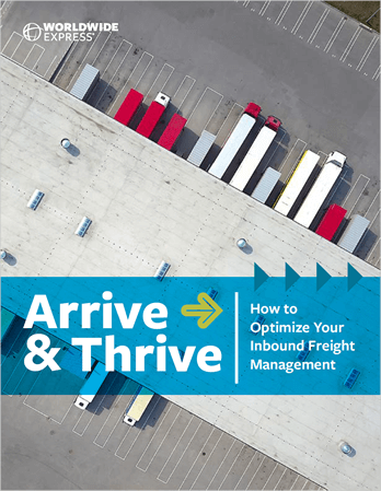 where colored arrows are painted to the left of the truck.|Aerial view of a white truck with a long trailer expertly backing into a loading dock at a blue industrial building. Nearby