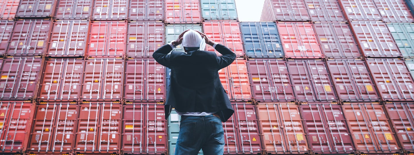 looking at a large stack of colorful shipping containers. Blue arrows are overlaid across the bottom of the image