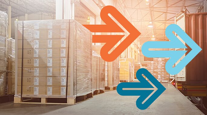 A warehouse interior with stacked pallets of boxes on the left. Two large colored arrows