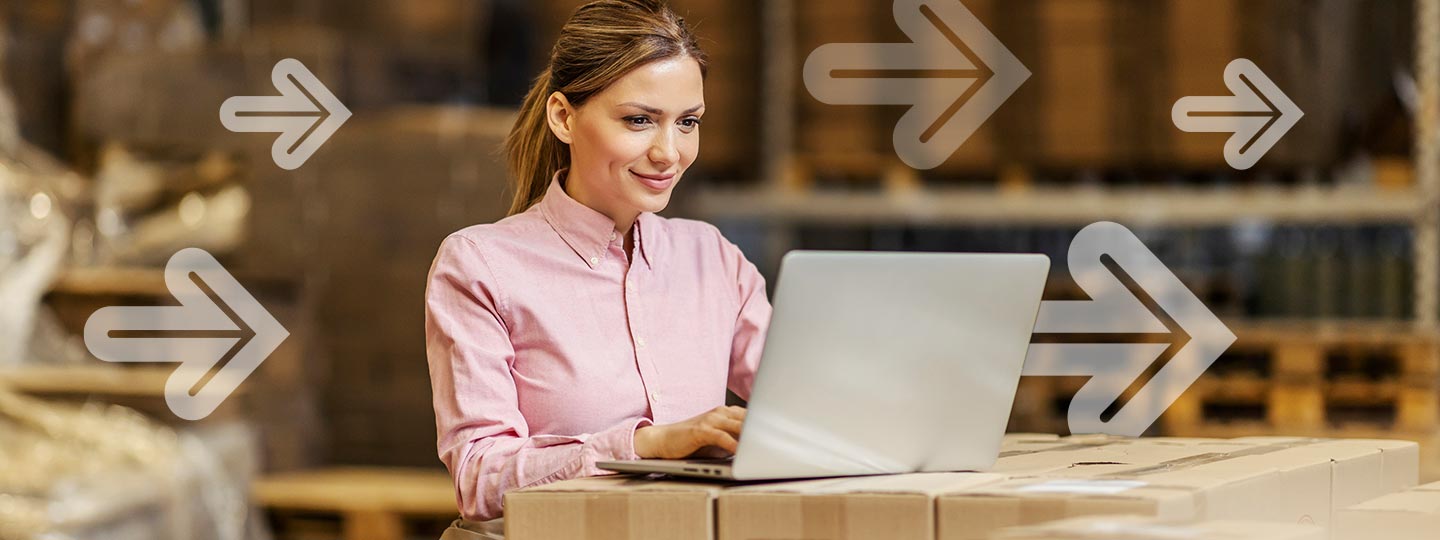 suggesting fast processing or movement.|A woman in a pink shirt is using a laptop while sitting on boxes in a warehouse bustling with 3PL logistics. Transparent arrow graphics are overlaid on the image