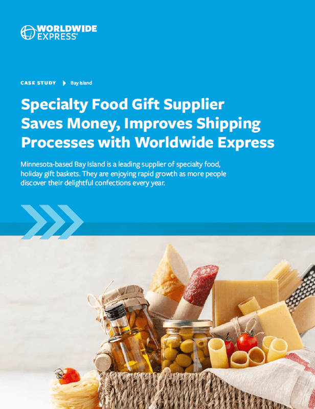 A gift basket filled with cheese, bread, a yellow apple, and jars of preserves sits in front of a blue background, highlighting how ADA Enterprises saves money and improves B2B logistics and shipping with Worldwide Express.