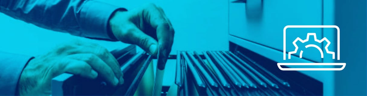 A person’s hands search through hanging files in a filing cabinet. A white icon of a laptop with a gear appears on the right, suggesting digital organization or E-Commerce Solutions. The image has a blue overlay.