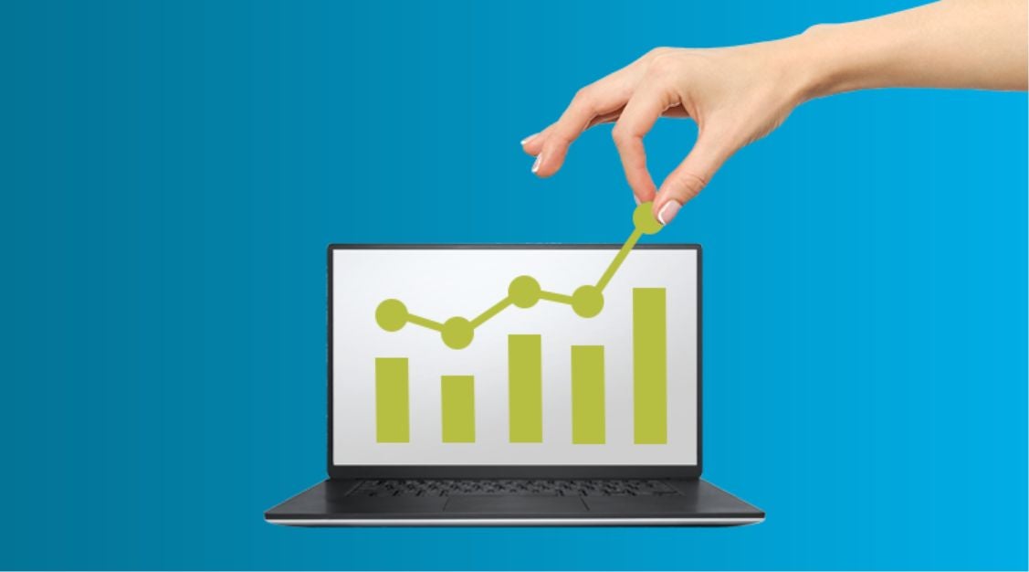 A hand adjusts a rising green line graph on a laptop screen, which also displays bar charts and supply chain control tower metrics, against a blue background.